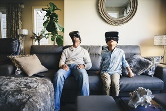Mixed race father and daughter using virtual reality goggles