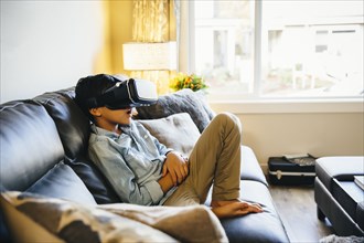 Mixed race boy using virtual reality goggles