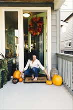 Mixed race woman arranging pumpkins on patio