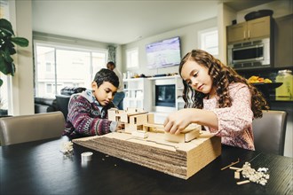 Mixed race children building model house
