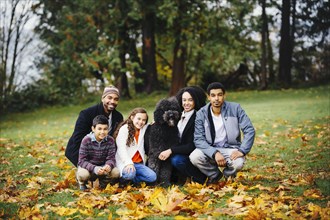 Family and dog smiling in park
