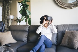 Mixed race woman using virtual reality goggles