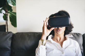 Mixed race woman using virtual reality goggles