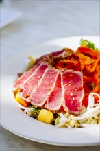 Plate of sliced tuna and salad