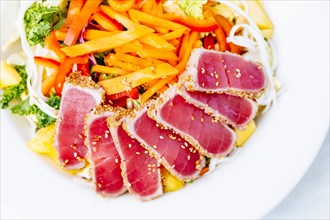 High angle view of sliced tuna and salad