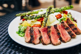 Plate of grilled meat and asparagus salad