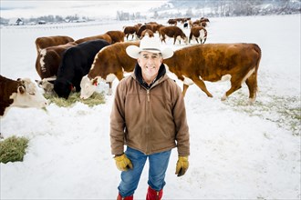 Caucasian farmer smiling in snowy field