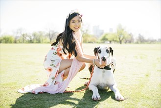 Chinese woman petting dog in field