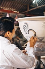 Artist painting pots in studio