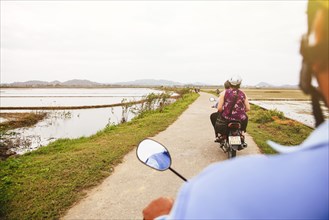 Caucasian man driving scooter in rural landscape