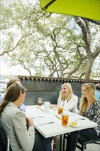 Caucasian women talking at table on restaurant patio