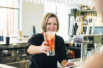 Caucasian bartender serving cocktail