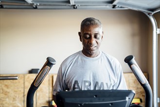 Black man using treadmill in garage