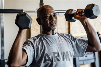 Black man lifting weights in garage
