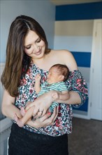 Hispanic woman holding sleeping baby boy