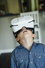 Caucasian boy wearing virtual reality goggles
