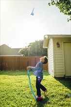 Caucasian boy flying toy rocket in backyard
