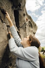 Caucasian woman climbing rock climbing wall