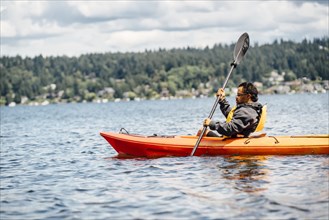 Mixed Race man paddling kayak