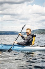 Caucasian man paddling kayak