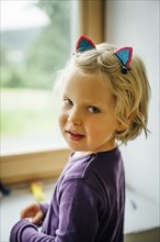 Smiling Caucasian girl wearing cat ears