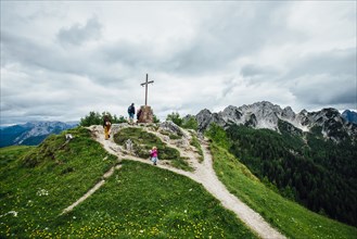 People climbing hill to crucifix