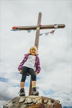 Caucasian girl posing on rock at crucifix