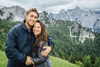 Caucasian couple hugging neat mountain range