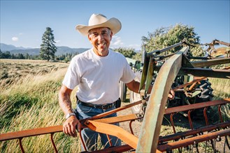 Portrait of Caucasian farmer standing near tractor