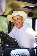 Portrait of smiling Caucasian farmer in tractor