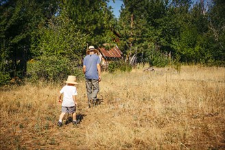 Caucasian grandfather and grandson walking in field