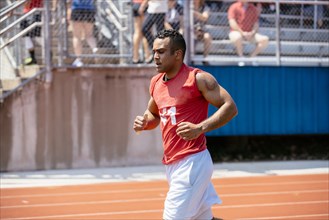 Hispanic man running on track