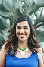 Portrait of smiling Mixed Race woman near cactus