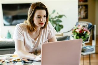 Woman sitting at table using laptop