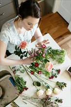 Woman arranging flowers at table