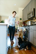 Woman training dogs in domestic kitchen