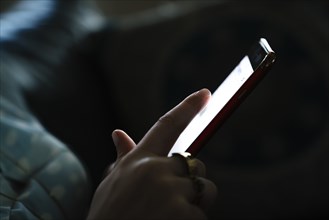 Woman texting on cell phone in the dark