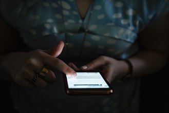 Woman texting on cell phone in the dark