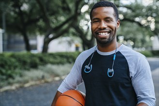 Portrait of smiling Black man holding basketball