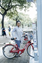Black woman posing with rental bicycle