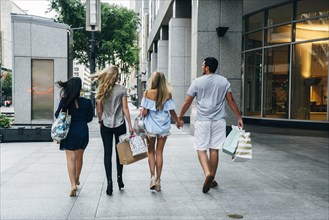 Friends carrying shopping bags in city