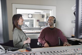 African dj working at radio station with co-worker
