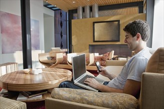 Middle Eastern man using laptop and cell phone