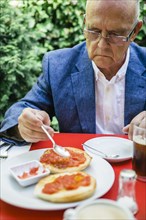 Hispanic businessman eating breakfast outdoors