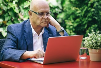 Hispanic businessman using laptop outdoors