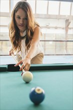 Hispanic woman playing pool