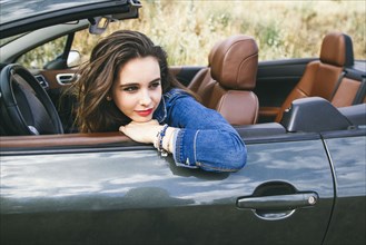 Caucasian woman sitting in convertible