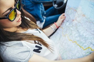 Woman reading map on road trip