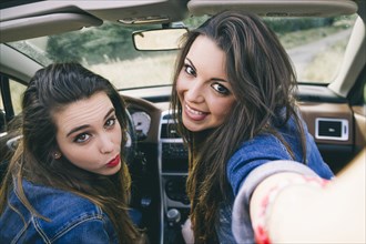 Women taking selfie in convertible