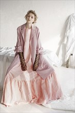 Portrait of serious Caucasian woman wearing pink dress
